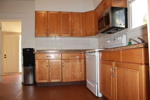 a kitchen with wooden cabinets and a stove and a microwave