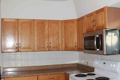 a kitchen with wooden cabinets and a stove and a microwave
