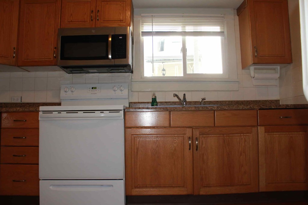 a kitchen with white appliances and wooden cabinets