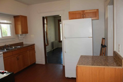a kitchen with a white refrigerator and wooden cabinets