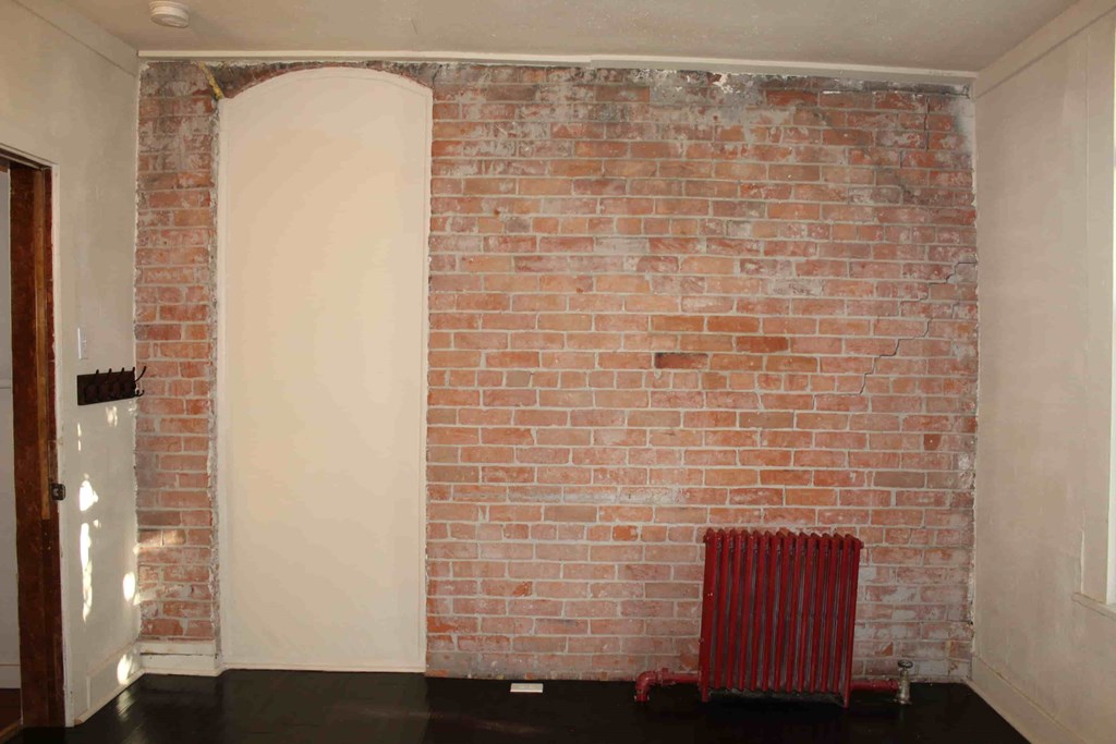 an exposed brick wall in a room with a radiator