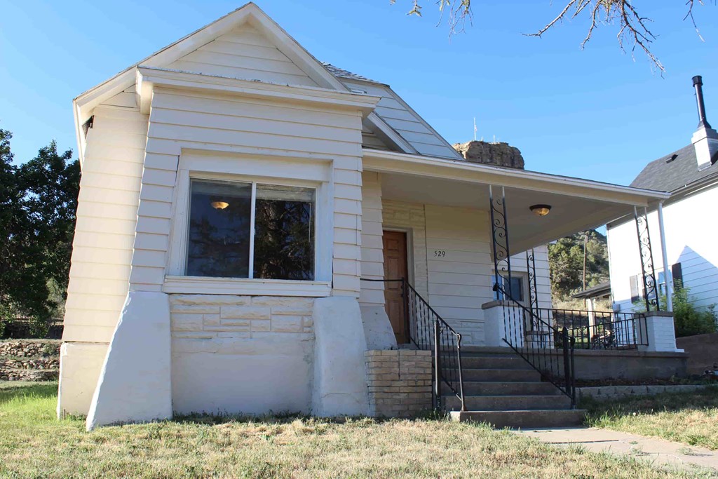 an old with a front porch and stairs