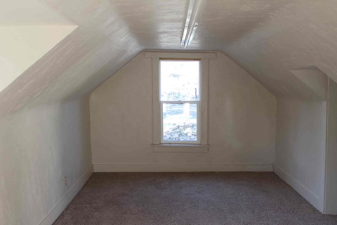 a room in a attic with a window