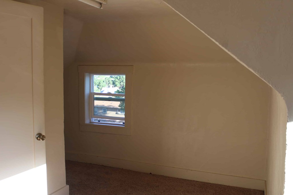 a small window in a white wall in a room