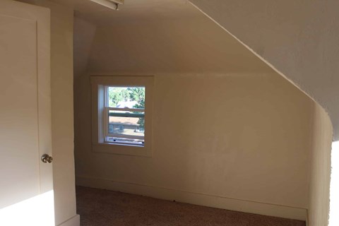 a small window in a white wall in a room