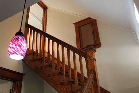 a spiral staircase in a home with a pendant light