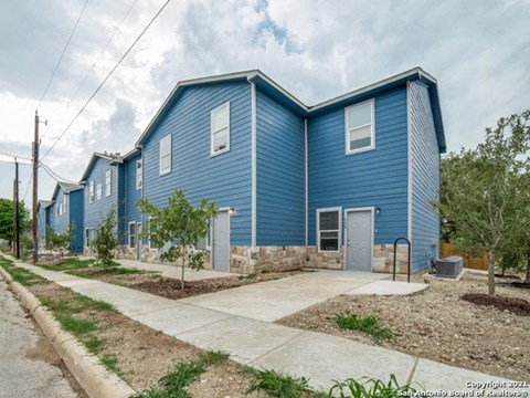a blue house with a sidewalk in front of it