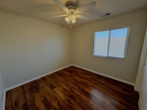 a living room with hardwood floors and a ceiling fan