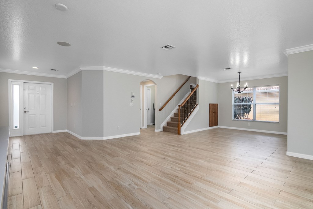 an empty living room with white walls and wooden floors