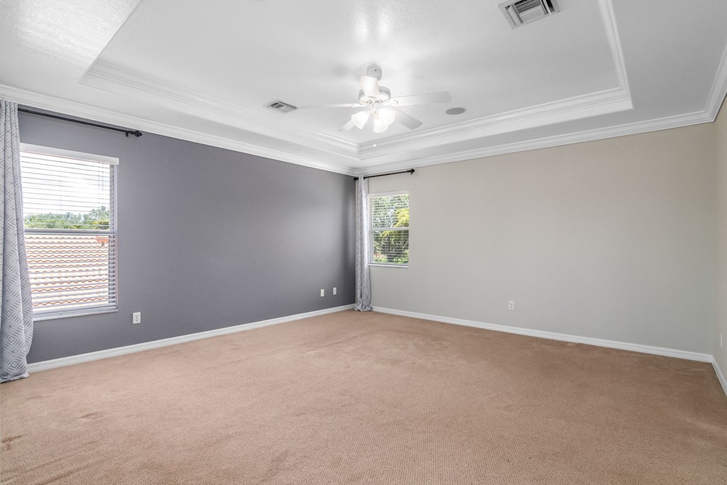 an empty living room with a ceiling fan and a window