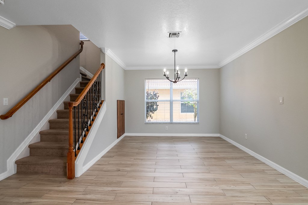 an empty living room with a staircase and a window
