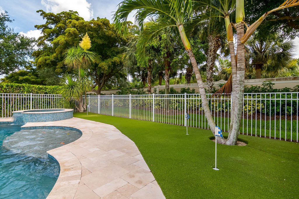 a backyard with a pool and a wrought iron fence