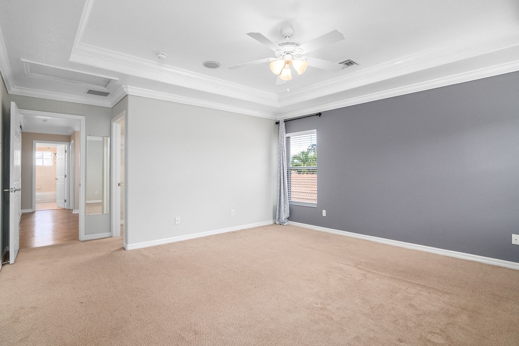 an empty living room with a ceiling fan