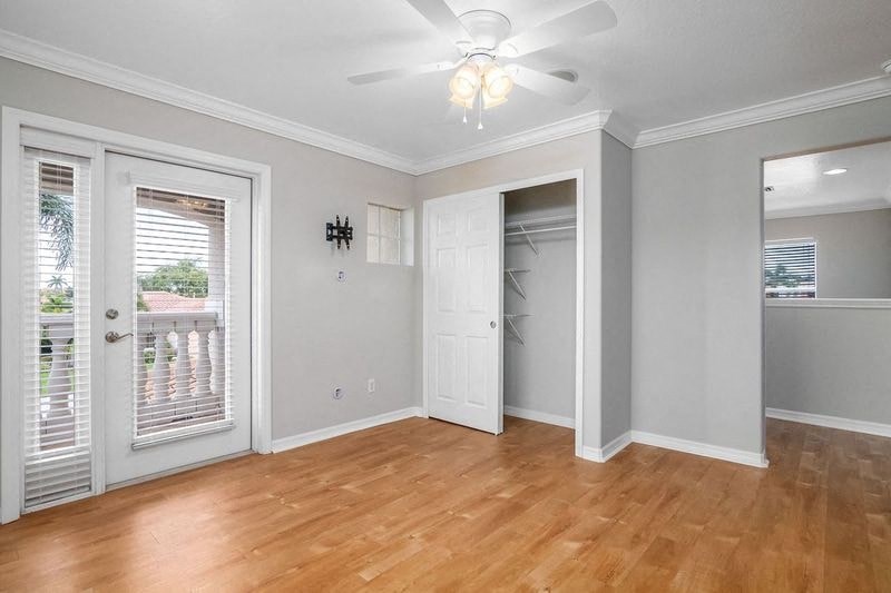 an empty living room with a ceiling fan and a closet