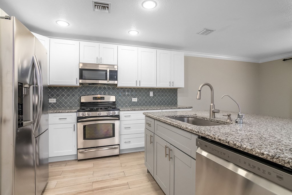 an empty kitchen with granite counter tops and stainless steel appliances