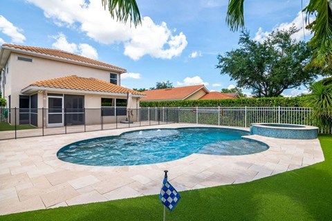 a swimming pool and a house with a fence around it