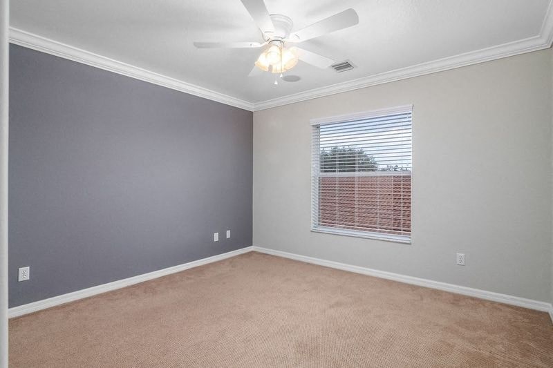 an empty room with a ceiling fan and a window