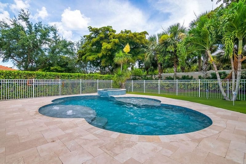 a pool and spa in a yard with palm trees