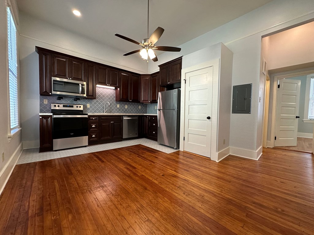 an empty kitchen with wood flooring and
