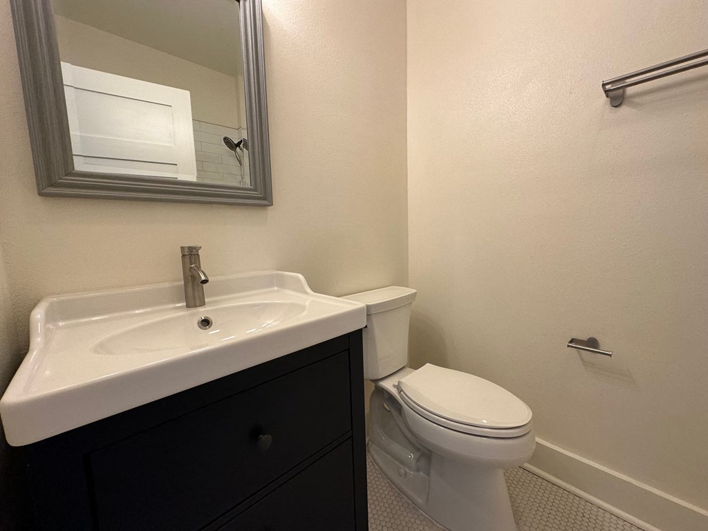 a bathroom with a sink toilet and mirror