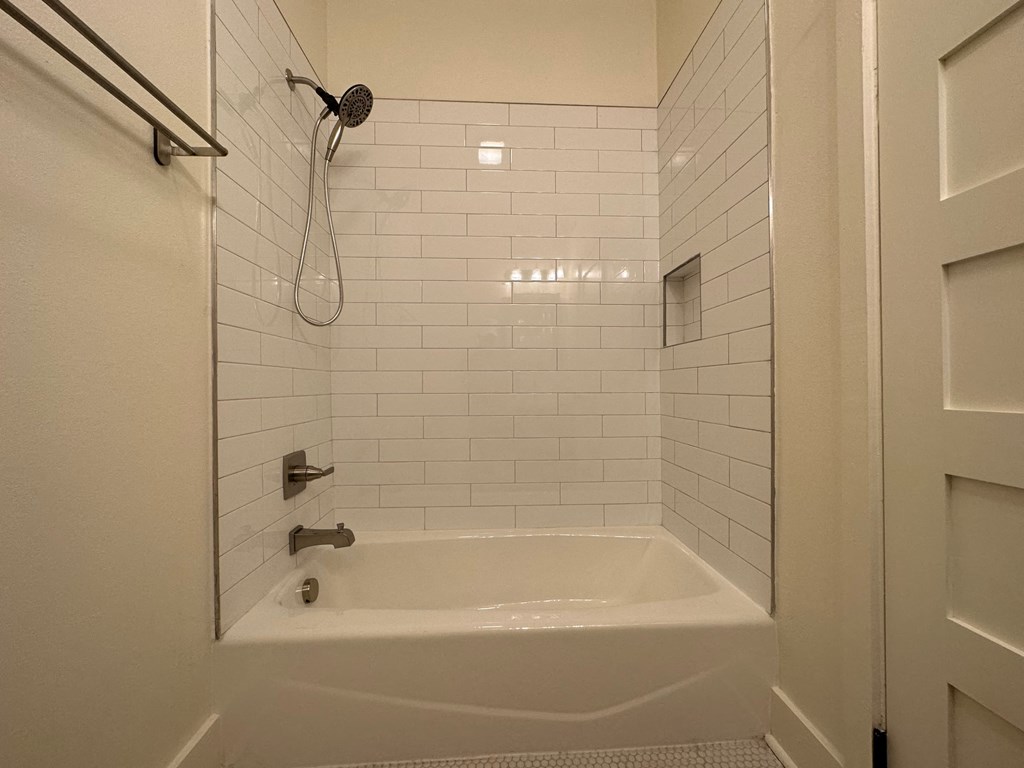a white bathroom with a shower and a tub
