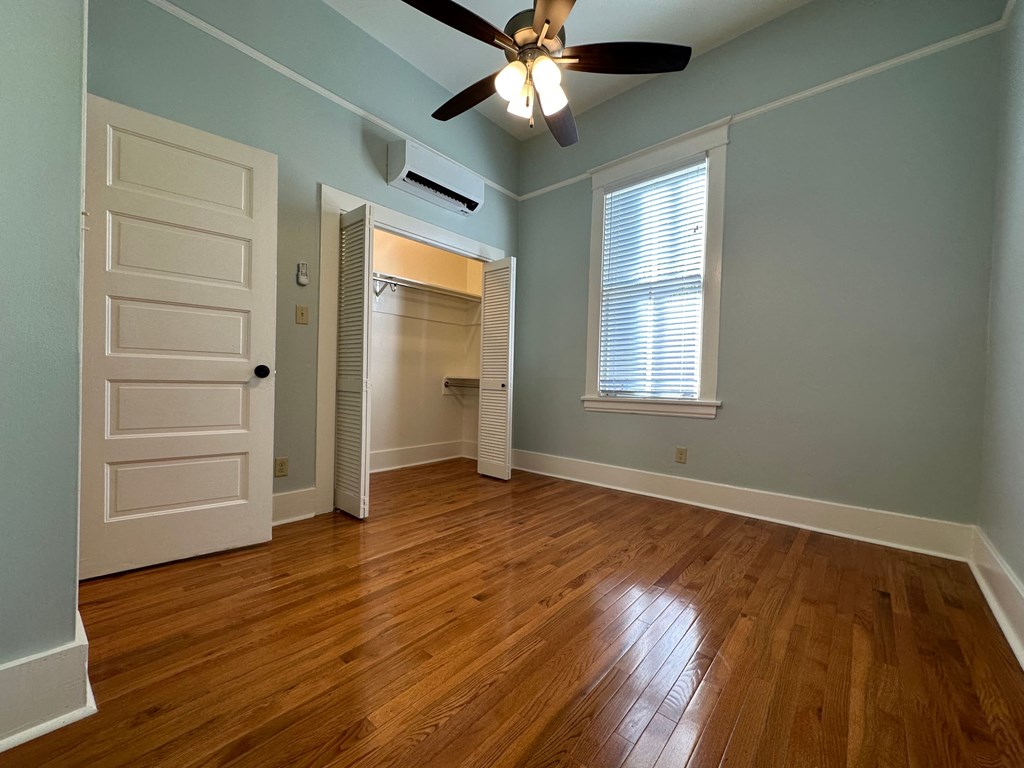 an empty room with a closet and a ceiling fan