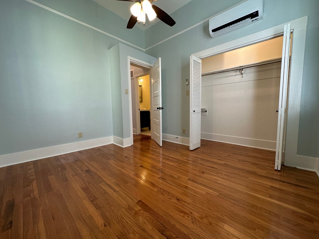 a living room with a hard wood floor and a door to a closet