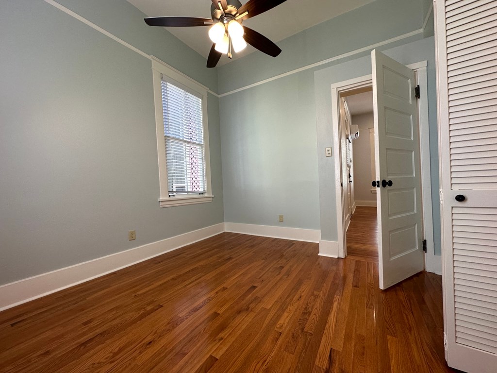 the living room of a house with wood floors and a ceiling fan