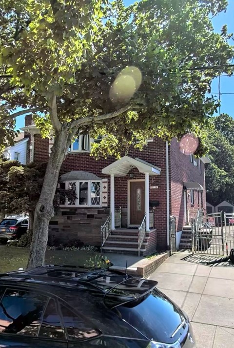 a house with a tree and a car parked in front of it
