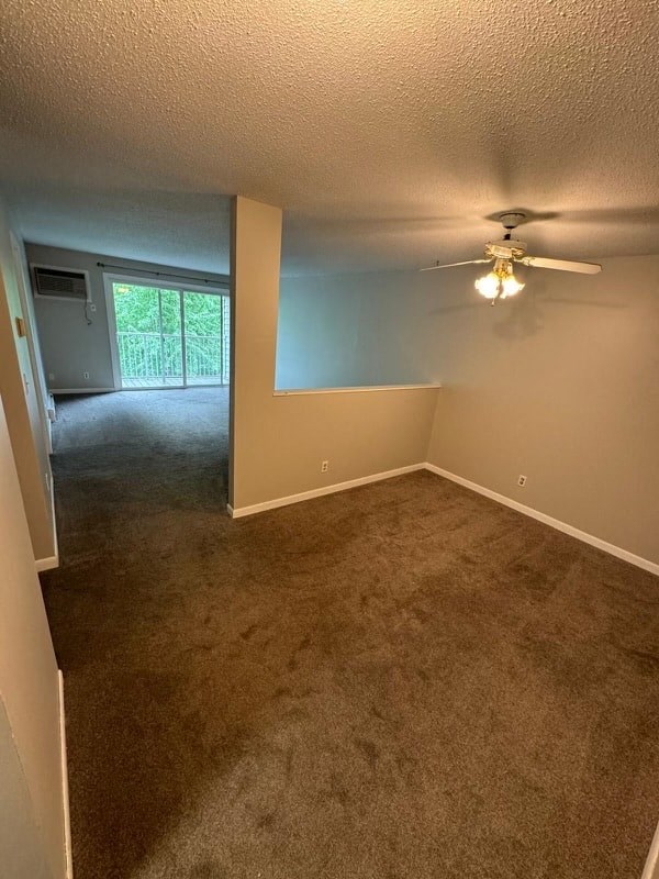 an empty living room with a ceiling fan