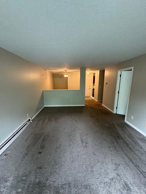 an empty living room with a carpeted floor and white walls