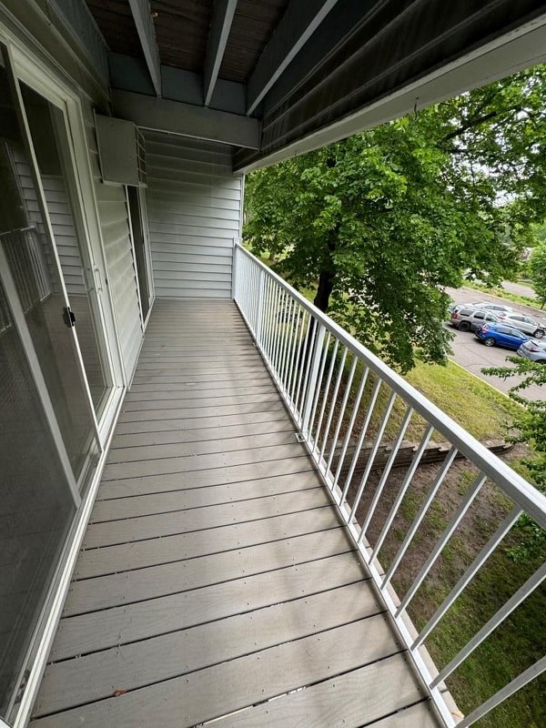 a balcony with a wooden floor and a metal railing