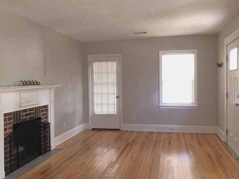 a living room with a fireplace and a wooden floor