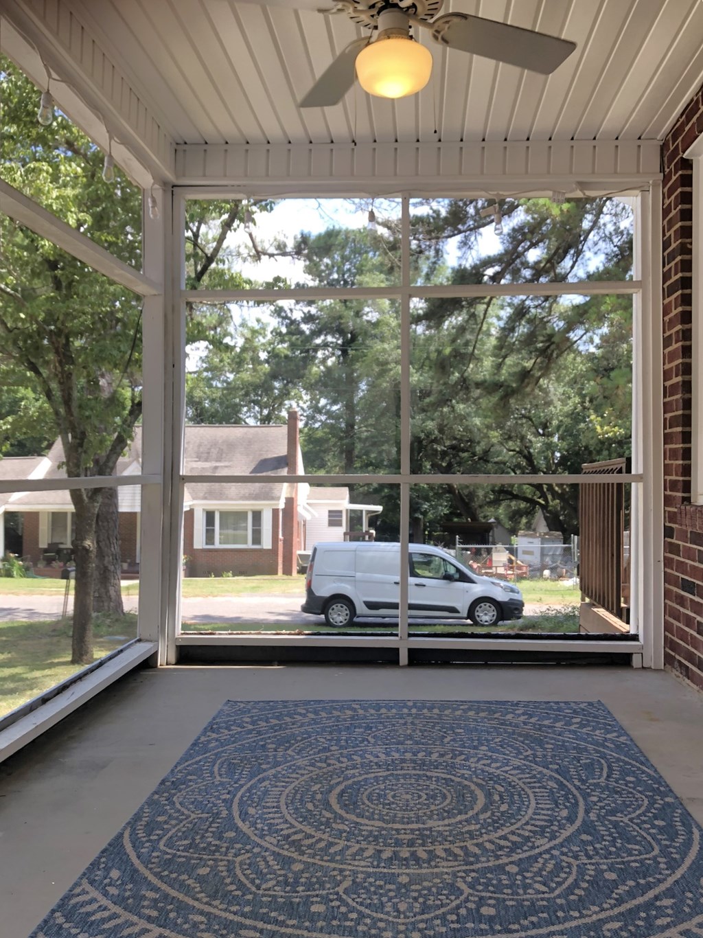 the view from the front porch of a house of a car parked in the yard