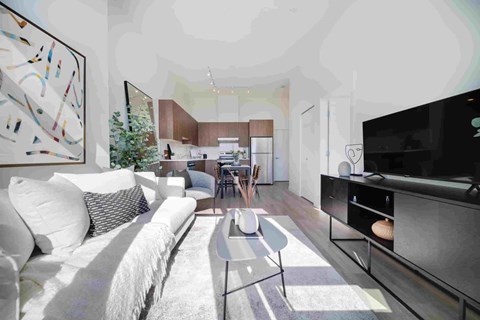 A modern living room with a white couch and a large abstract painting on the wall.