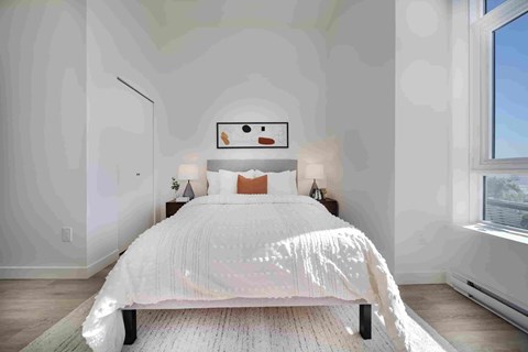 A bedroom with a large bed and a window.