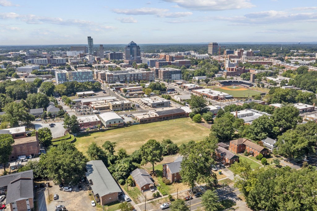 an aerial view of the city with a field in the foreground