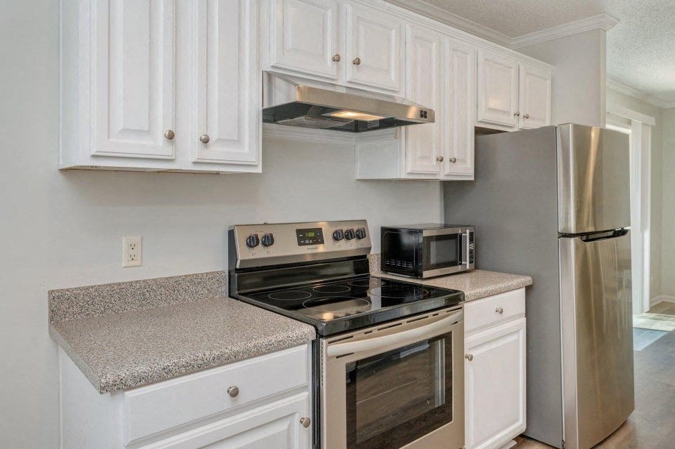 a kitchen with white cabinets and stainless steel appliances
