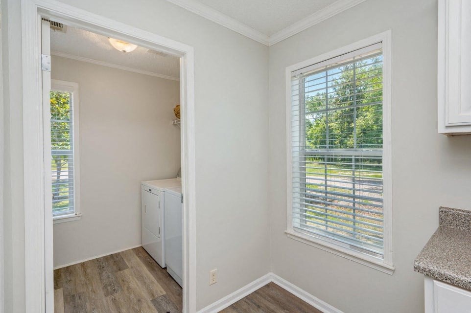 a small kitchen with a large window and a door to a laundry room