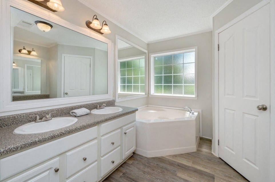 a bathroom with two sinks and a tub and a mirror