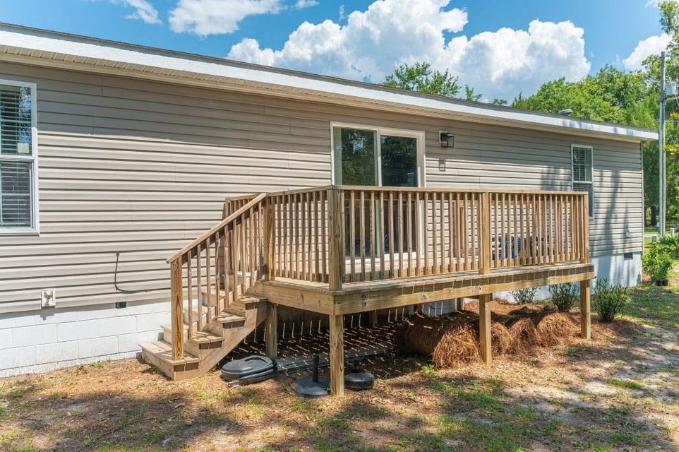 the front of a house with a deck and a staircase