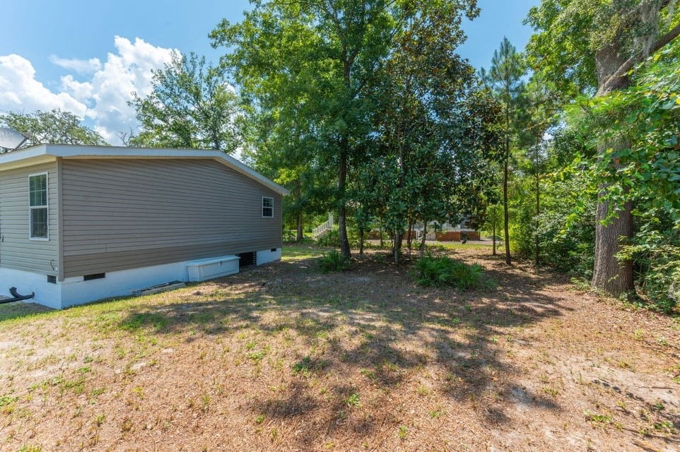 a mobile home is parked next to a yard with trees