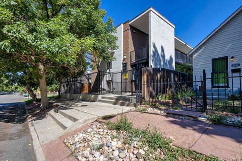 A modern house with a black gate and a stone pathway leading to the entrance.