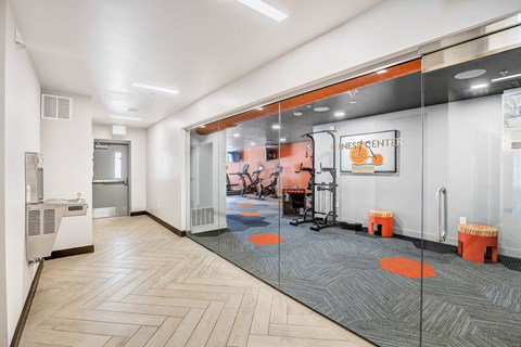 a room with glass doors and a gym with desks and chairs