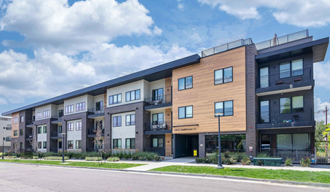 a rendering of a new apartment building on a city street