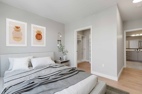 a bedroom with a bed and two paintings on the wall
