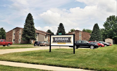 a sign sits in the grass in front of a building
