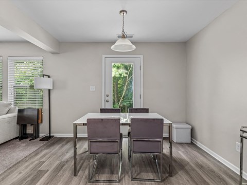 a dining room with a table and chairs and a window