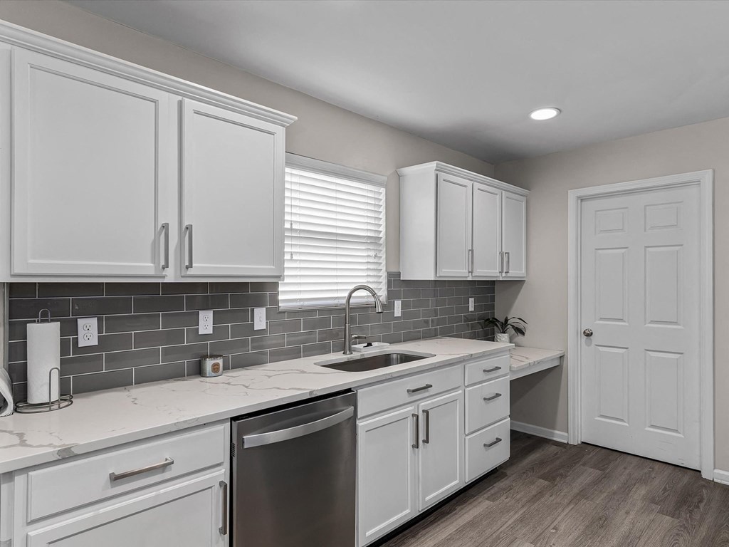 a white kitchen with white cabinets and a sink