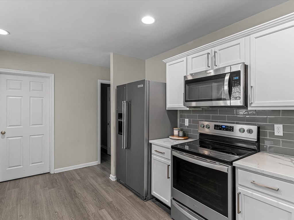 a kitchen with stainless steel appliances and white cabinets